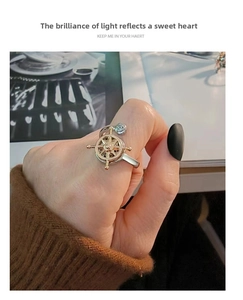 Detailed view of spinning gold nautical helm ring for anxiety relief on finger