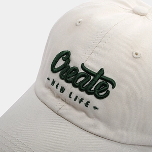 Close-up of vintage cotton baseball cap with green 3D embroidery and twill texture