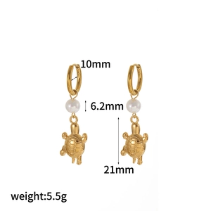 Macro shot of gold turtle and pearl drop earrings with dimensions and weight specs