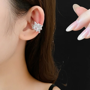 Detailed close-up of a silver snowflake ear bone cuff with sparkling zircon on ear