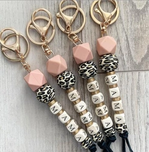 Close-up of silicone MAMA letter bead keychains with leopard print beads and gold clasp