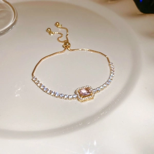 Detail of adjustable gold bracelet with pink rectangular zircon and pavé crystals