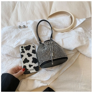 Close-up of luxury black rhinestone bucket bag with shiny silver crystals and drawstring