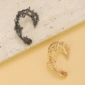 Gothic dragon wing ear cuff in silver and gold tones with vibrant red gemstones