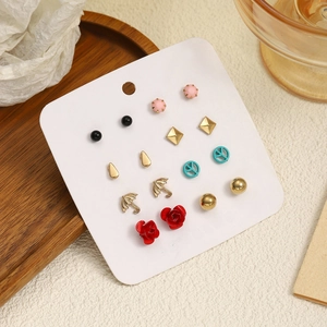 Lot de 7 paires de boucles d'oreilles assorties avec roses et étoiles sur présentoir