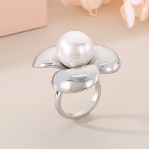 Dettaglio dell'anello a petalo lucido con una grande perla bianca in finitura oro 18K