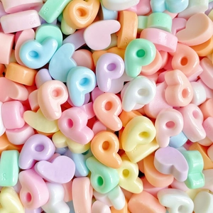 Macro shot of colorful resin heart beads in pastel colors for DIY jewelry making
