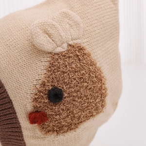 Winter knitted baby hat with rabbit ears and warm lining in beige and brown colors