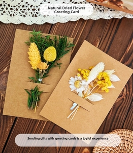 Detail of handmade greeting cards featuring natural dried flowers on kraft paper cards