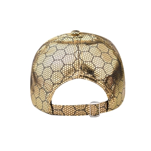 Detail of gold baseball cap rear view with black honeycomb pattern and metal buckle