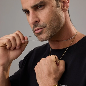 Detail shot of silver and gold 18K stainless steel snake chains on neck and gold ring