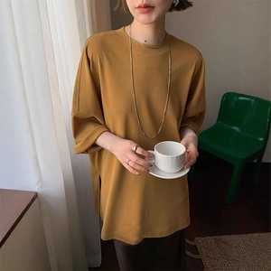Detail view of mustard yellow oversized t-shirt with side slits and premium cotton texture