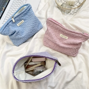 Detailed view of seersucker makeup bags with zipper closure in soft pastel colors