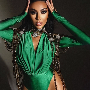 Close-up of green long sleeve bodysuit featuring ornate gold fringe and metallic details