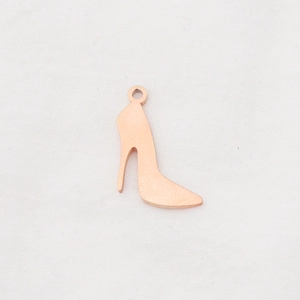Macro detail of rose gold high heel shoe pendant with polished mirror finish for DIY jewelry