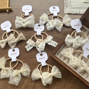 Elegant white lace bow hair ties with pearl accents and elastic bands in a set
