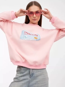 Nahaufnahme von rosa Sweatshirt mit Rundhalsausschnitt, russischem Text und Kuh-Illustration