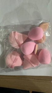 Macro shot of 12-piece pink mini makeup sponge set in clear packaging for detailed view