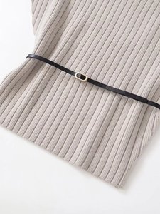 Close-up of grey ribbed knit fabric with a slim black belt and gold oval buckle detail