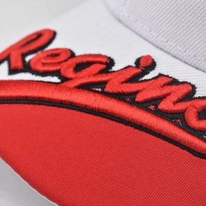 Macro detail of high-quality Redwing 3D embroidery on a contrast red and white baseball cap