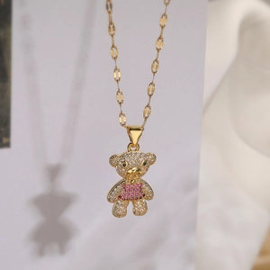 Detail of bear pendant with white and pink rhinestones on a gold-plated chain necklace
