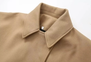 Detailed close-up of wool texture and lapel collar on a camel brown oversized jacket