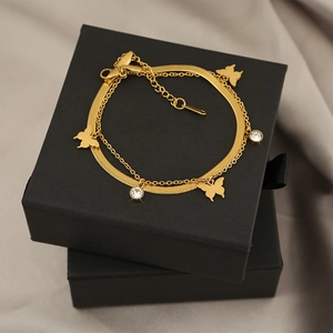 Detail view of double-layer gold titanium bracelet with butterfly charm and zircons