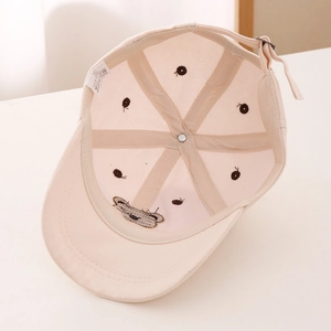 Detailed inner view of beige cotton baseball cap with reinforced tape and wash label