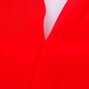 Détails macro d'une robe midi rouge plissée montrant la texture lisse et les coutures du col