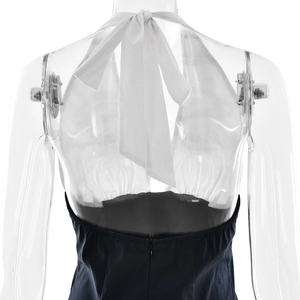 Back view of a white halter neck top with bow tie and black A-line skirt with back zipper