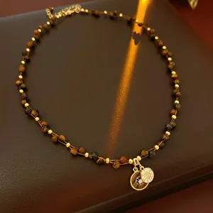 Tiger eye stone bead necklace with gold sunburst and blue eye pendant on leather