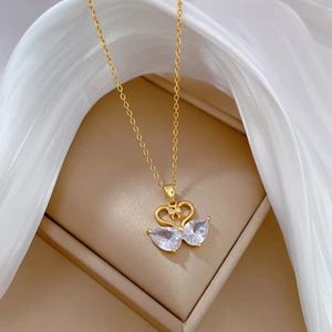 Detailed macro view of gold swan necklace with sparkling pear-shaped zirconia crystals