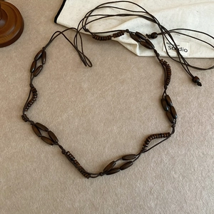 Detail view of ethnic wood beaded belt with dark resin and acrylic accents