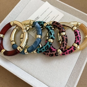 Détail macro de 6 bracelets en acrylique style bambou aux motifs léopard et unis
