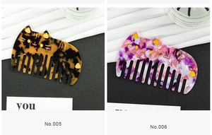 Close-up of cat-shaped tortoiseshell and purple marble acetate wide tooth hair combs