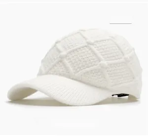 Close-up of off-white knitted baseball cap with textured diamond pattern stitching