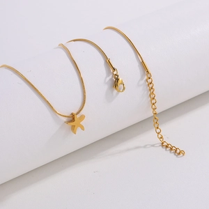 Detailed view of the gold-toned starfish pendant necklace with smooth snake chain and clasp
