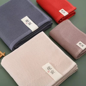 Japanese style waffle weave cotton towels in navy, red, pink and beige, folded with bands