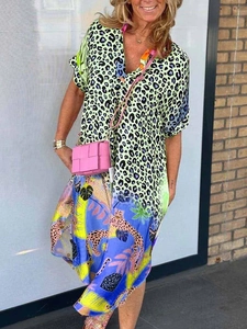 Detail of colorful mixed print dress showing green leopard and blue tropical patterns