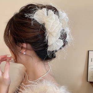 Détail de la pince à cheveux fleur crème avec texture à franges et tissu en organza délicat