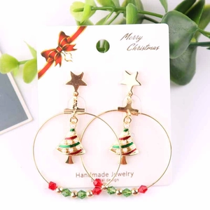 Detailed close-up of Christmas tree hoop earrings with stars and enamel charms