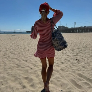 Vue de dos d'une mini-robe en tricot rayée rouge et blanc moulante sur la plage