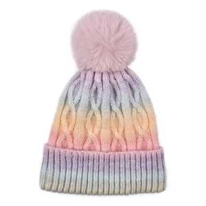 Macro detail of gradient cable knit hat with a large fluffy pink pom-pom decoration