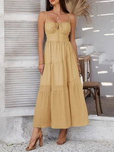 Detail of elegant beige sundress featuring slim straps and a layered ruffle hemline