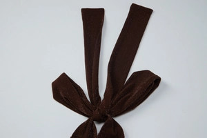 Macro shot of dark brown glitter knit fabric texture with metallic threads on a tie detail