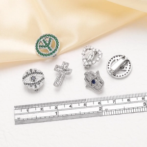 Detailed view of stainless steel charms with colorful zircon and evil eye religious motifs