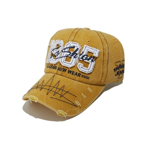 Detail of distressed brim and 1985 embroidery on vintage yellow washed baseball cap