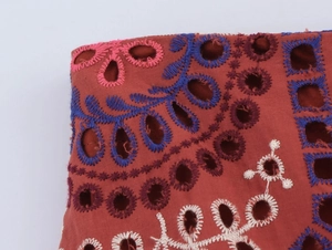 Detail der Stickerei auf rostrot Baumwolle mit bunten floralen Stickmustern