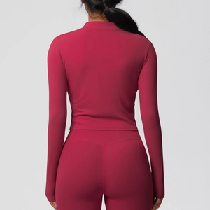 Détail du haut de yoga à manches longues rouge rose ajusté et du legging de sport