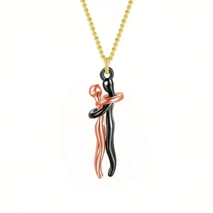 Close-up of black and rose gold hugging figures pendant on a gold chain necklace